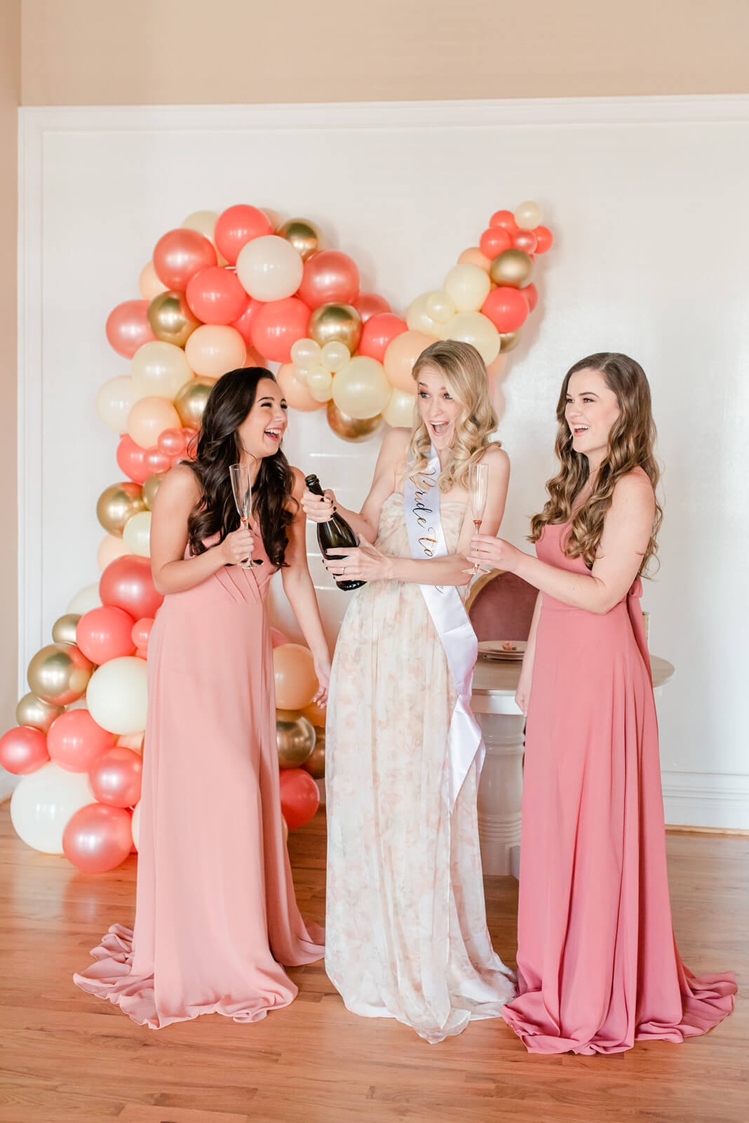 three women in long dresses celebrating at a party