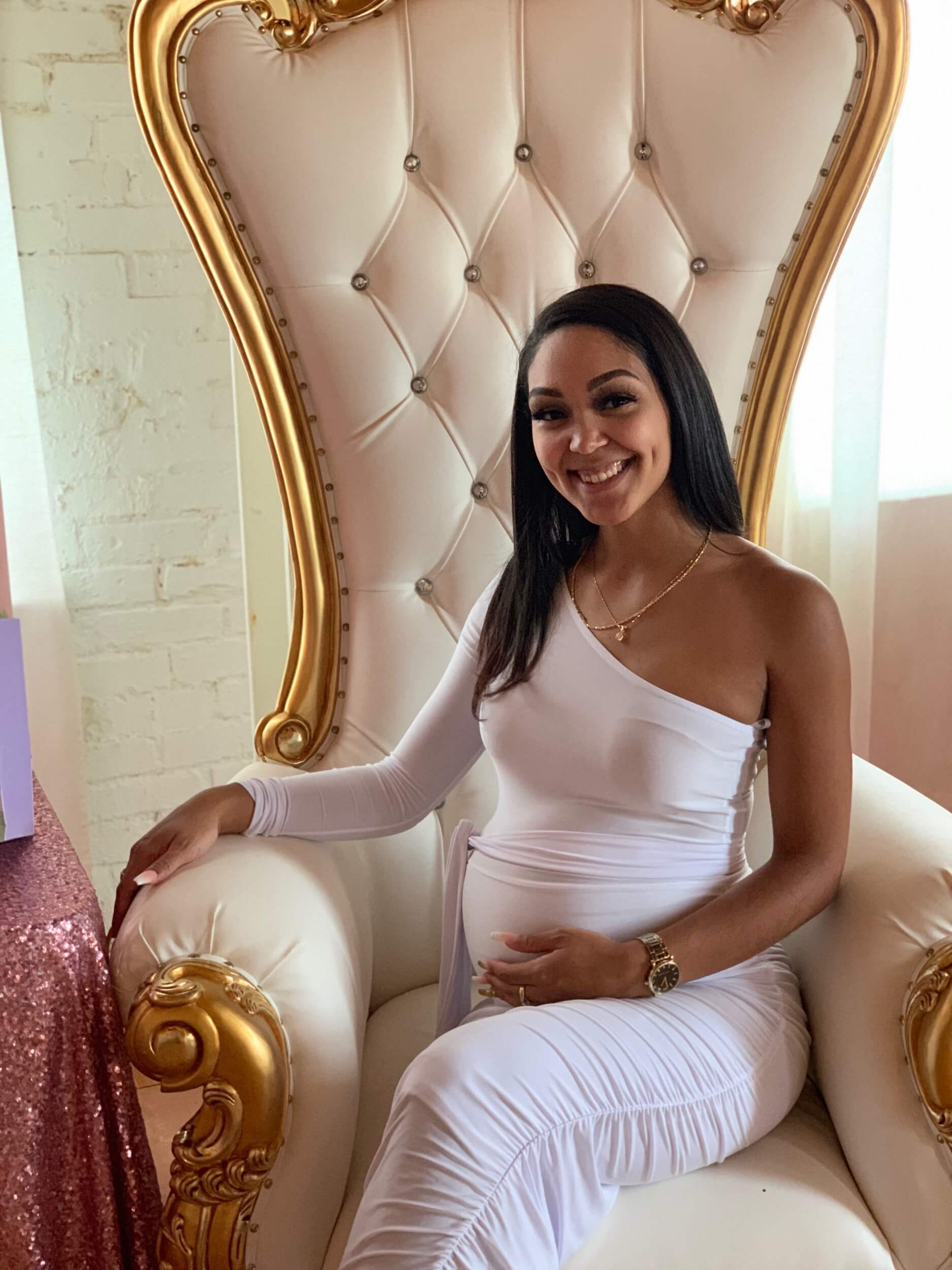 mom to be sitting in a fancy chair at a baby shower